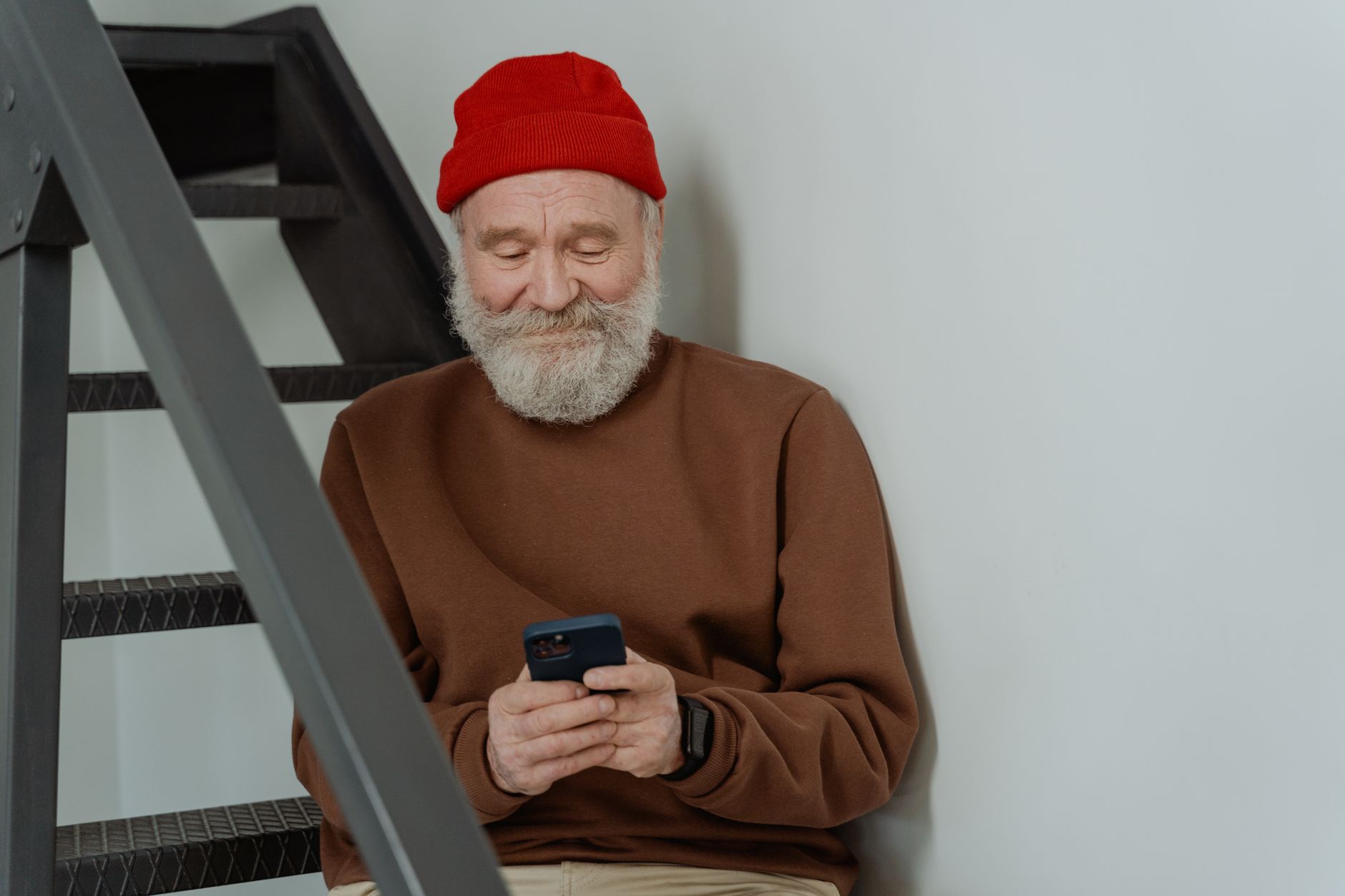 Senior wears a Samsung Galaxy Watch while checking an Android phone