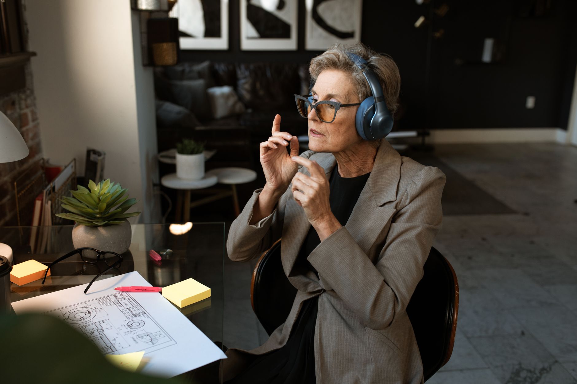 Older adult wearing large silver over-ear AirPods Max headphones