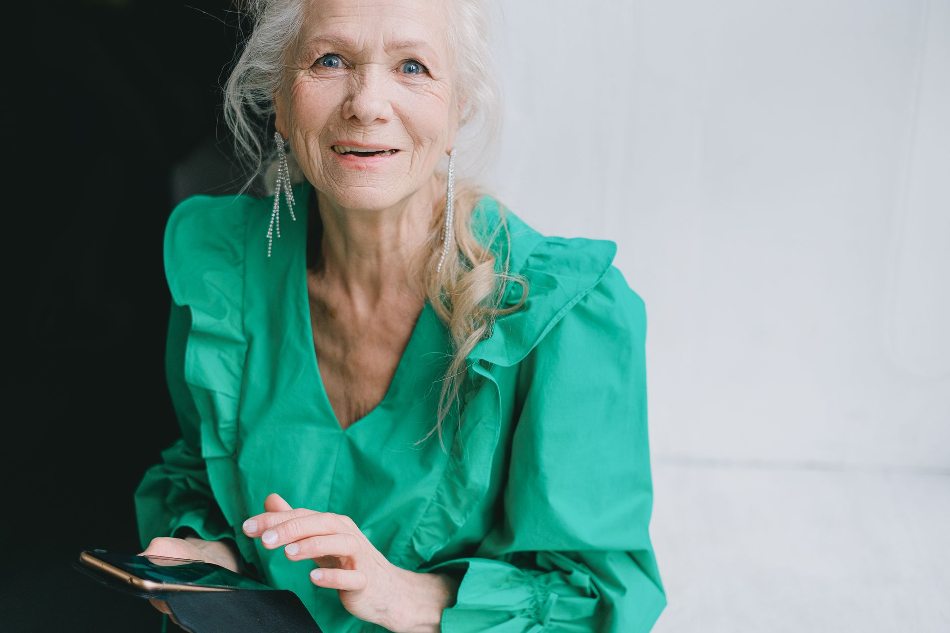 Older adult holds an Android phone showing the Google backup settings screen with large text