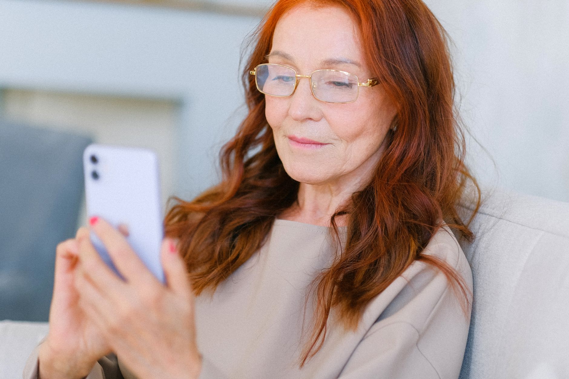 An older adult using an Android phone with the Caller ID and spam protection menu open.