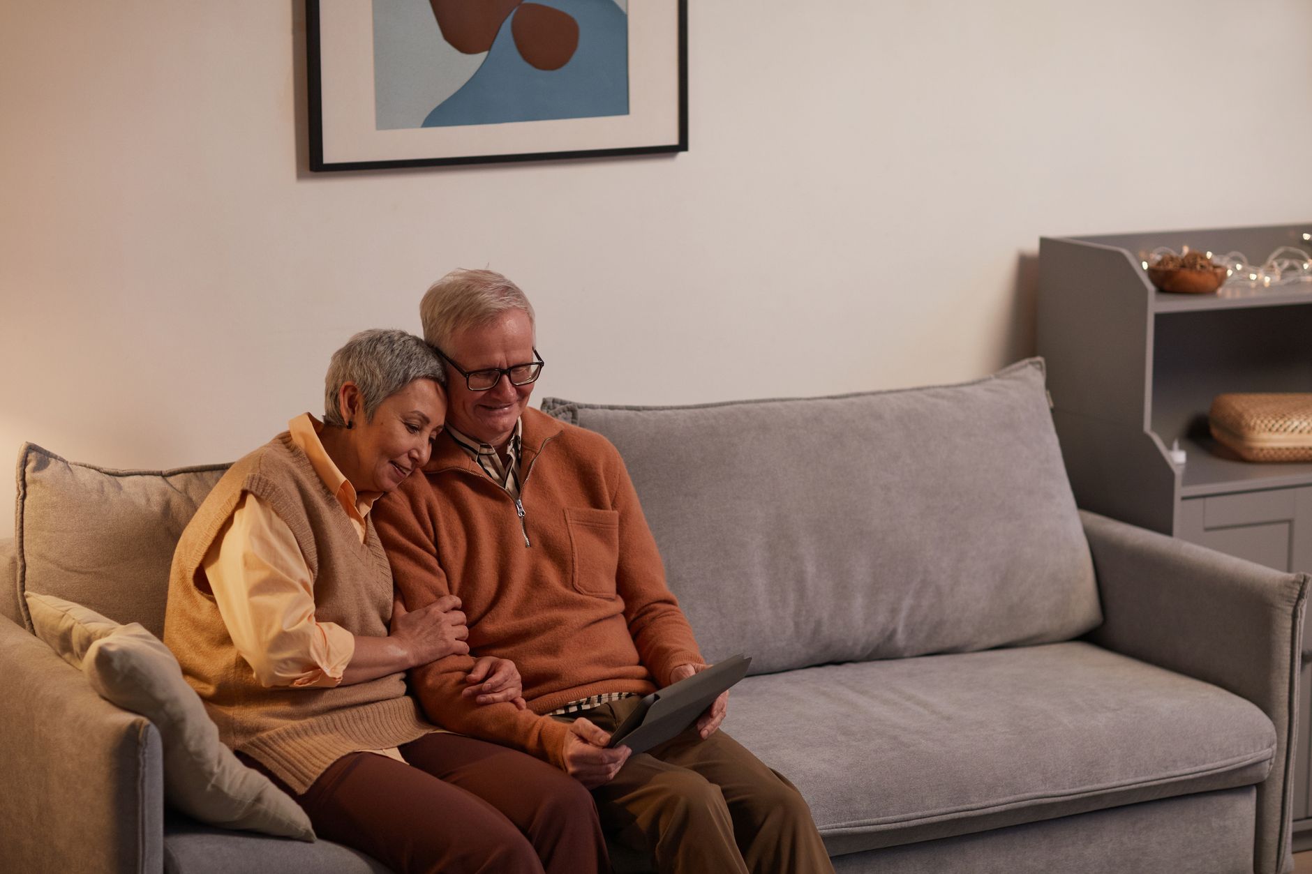 Senior sitting on a sofa and using an Android tablet