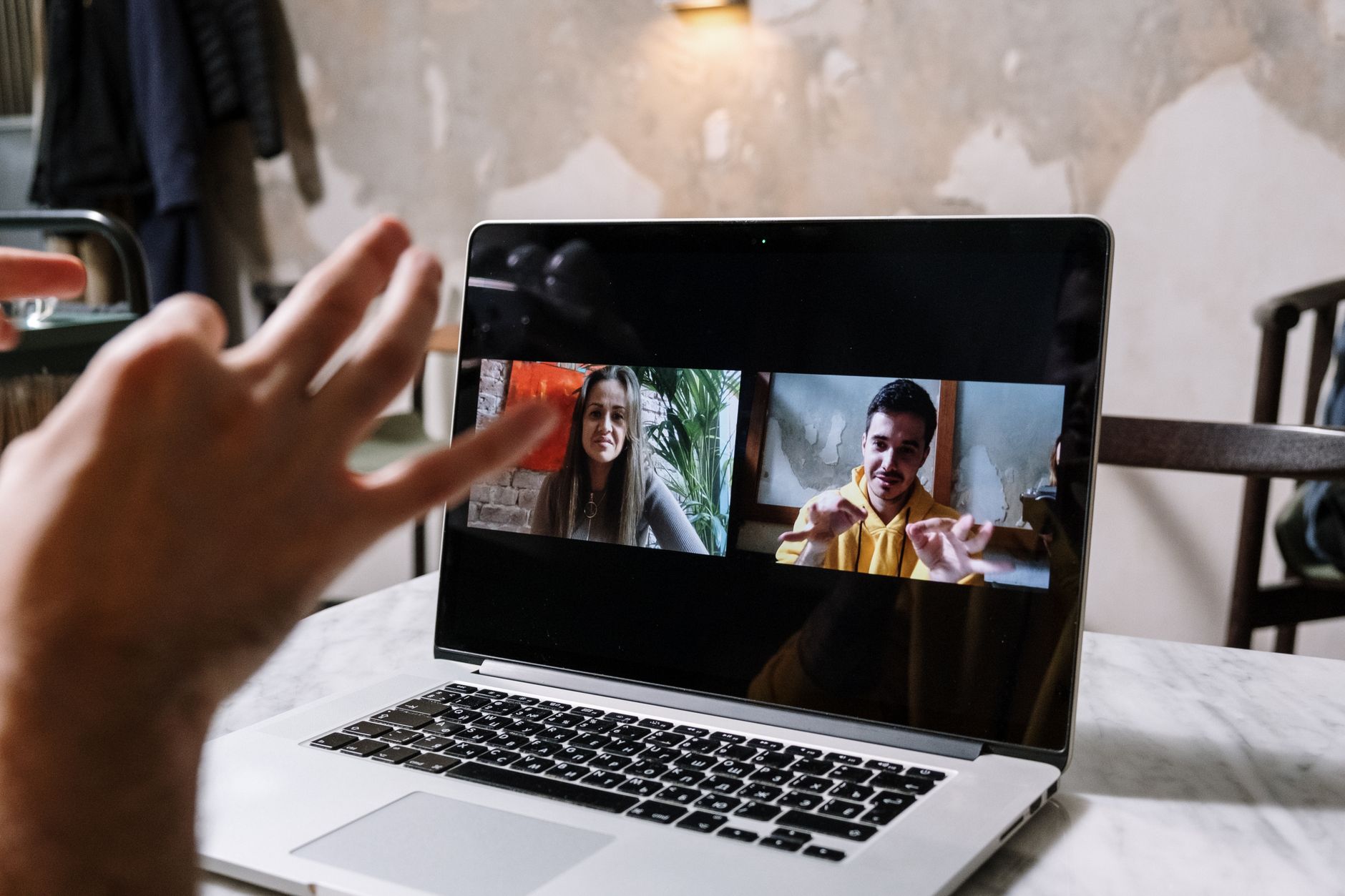 a person adjusting video call settings on a laptop in a bright room